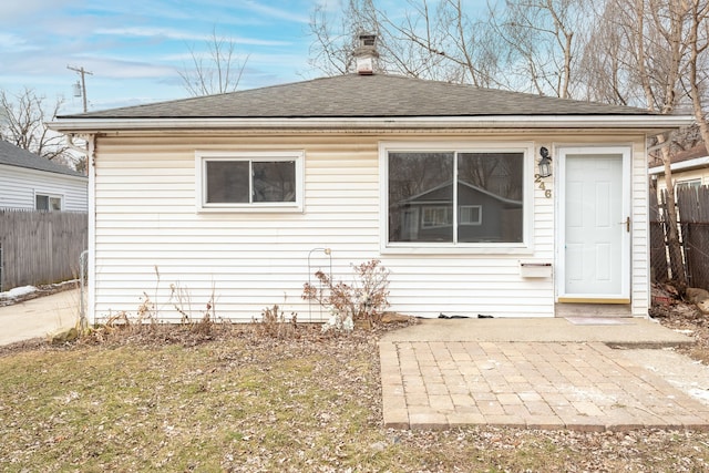 back of house with a patio area, a shingled roof, and fence