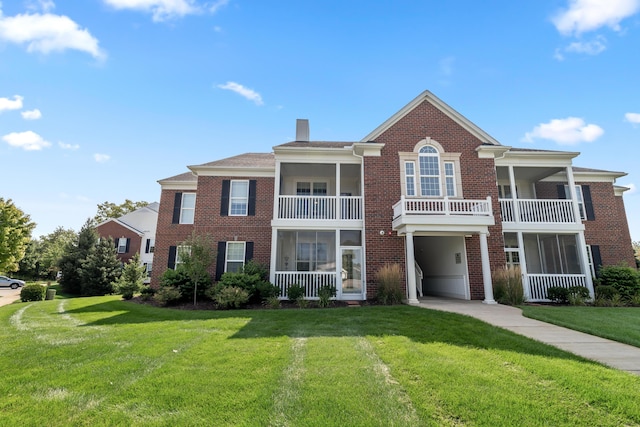 view of front of home featuring brick siding, a chimney, and a front yard