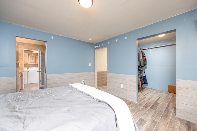 9915 85th Ave, Mecosta, MI 49332 - bedroom featuring a closet, wood finished floors, washer and dryer, a walk in closet, and a wainscoted wall
