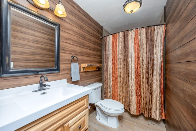 9915 85th Ave, Mecosta, MI 49332 - bathroom featuring wooden walls, toilet, wood finished floors, and vanity