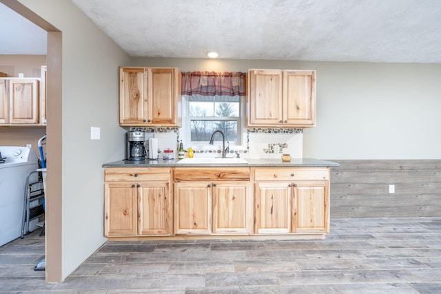 9915 85th Ave, Mecosta, MI 49332 - kitchen featuring light wood-style floors, washer / dryer, a sink, and light brown cabinets