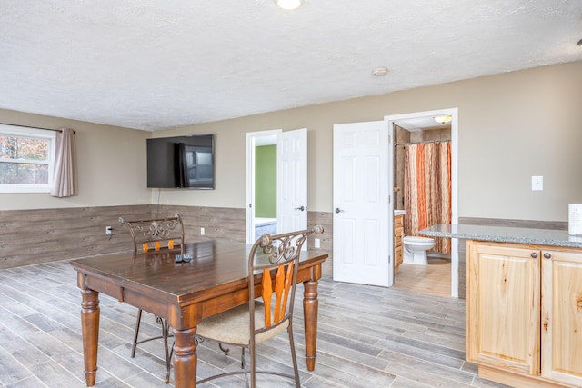 9915 85th Ave, Mecosta, MI 49332 - dining area with a textured ceiling, light wood finished floors, and wainscoting