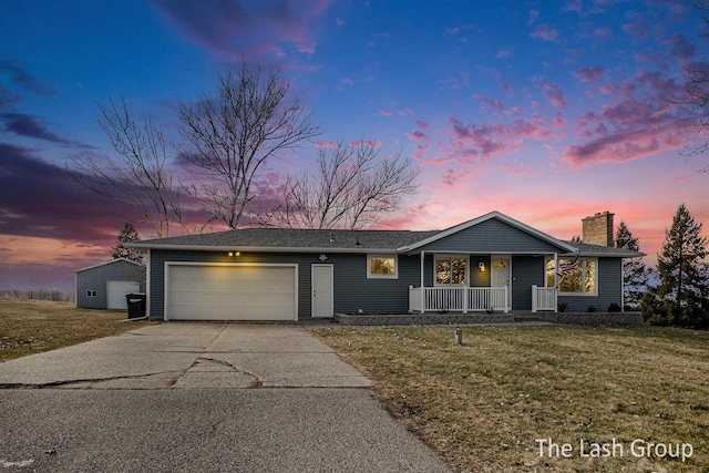 ranch-style house featuring a yard, a chimney, a porch, concrete driveway, and a garage