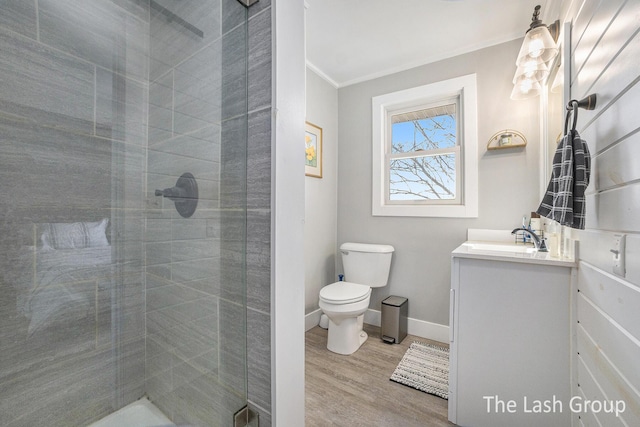 full bathroom featuring vanity, a shower stall, toilet, and crown molding