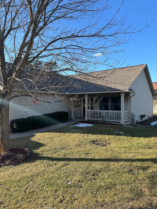 ranch-style house with roof with shingles, a porch, and a front yard