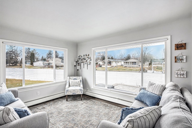 living room featuring plenty of natural light, wood finished floors, and a baseboard radiator