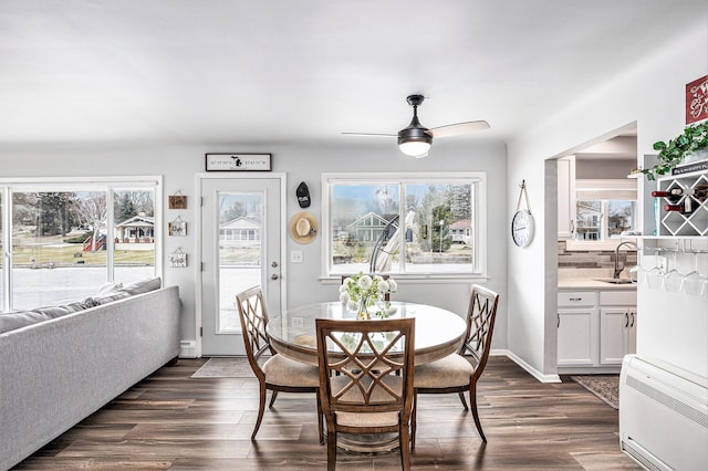 dining space with ceiling fan, baseboards, and dark wood finished floors