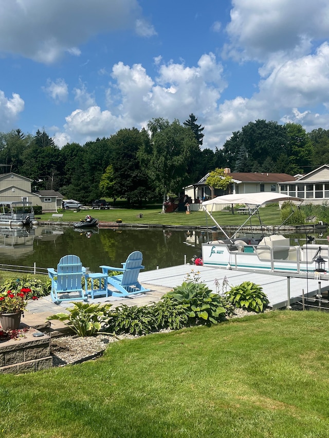 view of dock featuring a lawn and a water view