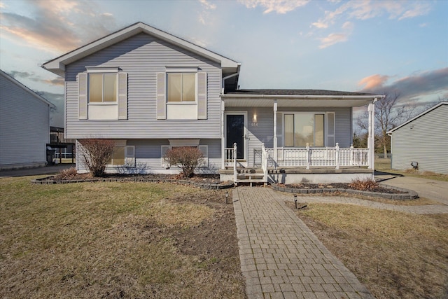 split level home with a front lawn and a porch