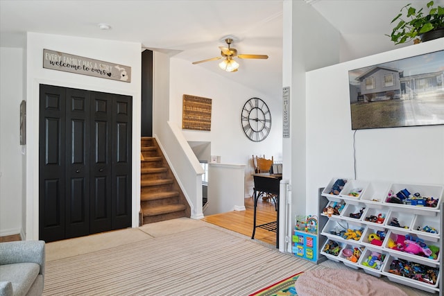 entrance foyer with lofted ceiling, ceiling fan, and stairway