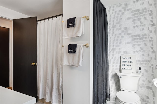 bathroom with toilet and a shower with curtain