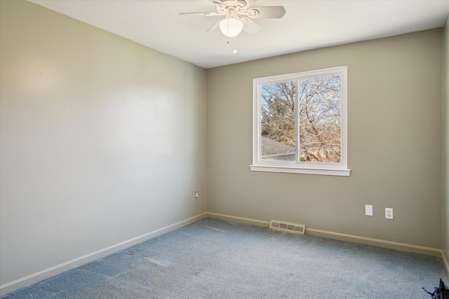 spare room with carpet floors, visible vents, ceiling fan, and baseboards