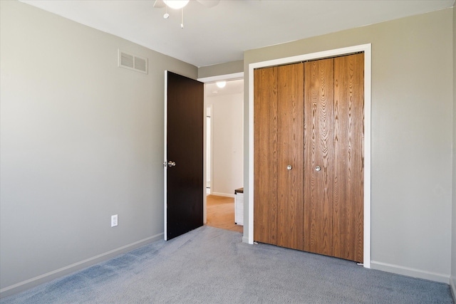 unfurnished bedroom featuring ceiling fan, visible vents, baseboards, a closet, and carpet