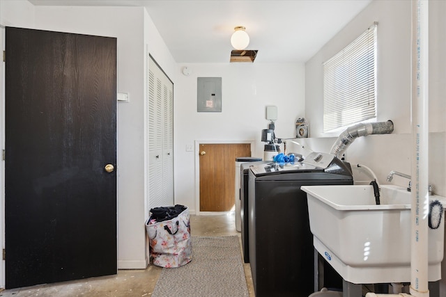 washroom featuring washer and dryer, laundry area, electric panel, and a sink