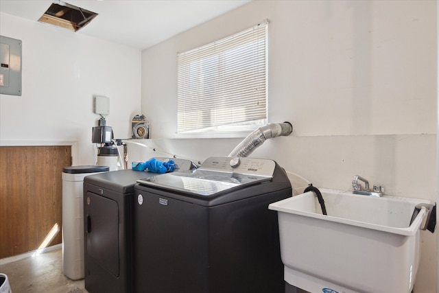 washroom featuring laundry area, electric panel, a sink, and washer and clothes dryer