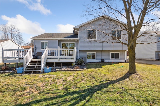 rear view of house with a wooden deck and a yard