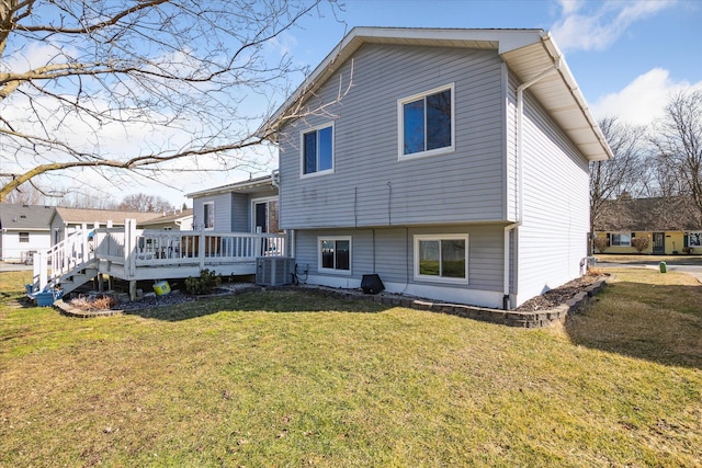 rear view of house with a lawn and a wooden deck