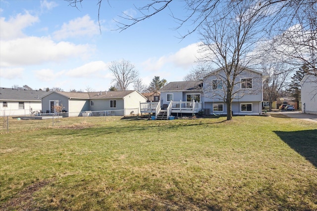 rear view of property featuring fence private yard, a residential view, a lawn, and a deck