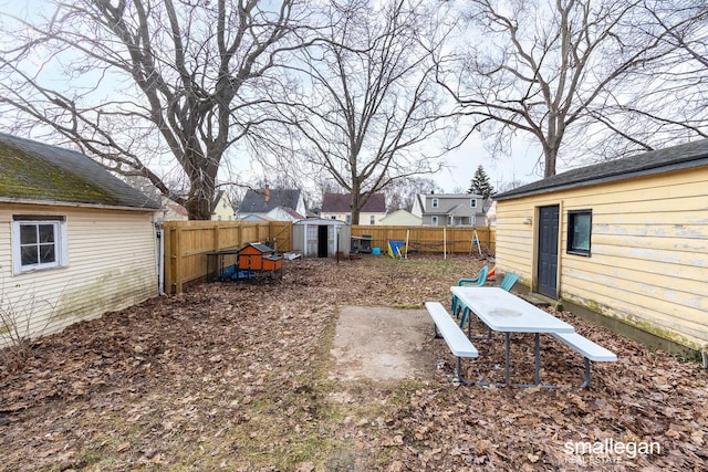 view of yard with a fenced backyard, an outdoor structure, and a shed