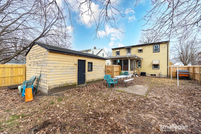 back of house with an outbuilding, a patio, a fenced backyard, and a sunroom