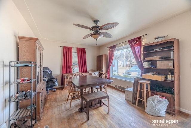 dining area with a ceiling fan, visible vents, baseboards, and hardwood / wood-style flooring