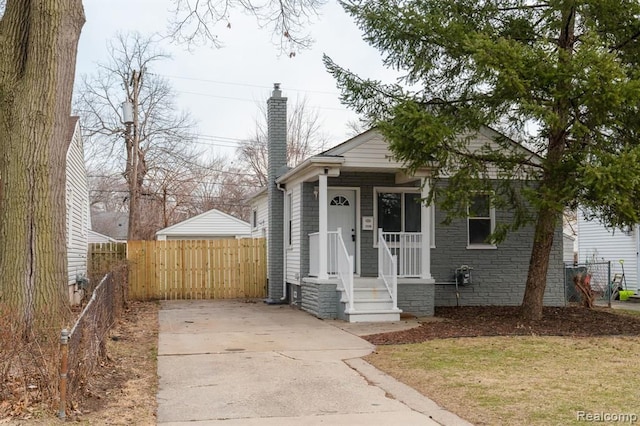 view of front of house with a chimney and fence