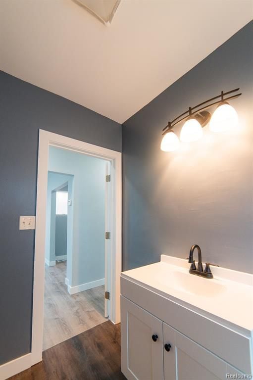 bathroom featuring a sink, baseboards, and wood finished floors