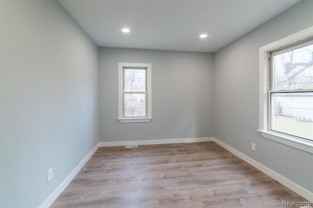 spare room with a healthy amount of sunlight, light wood-style flooring, and baseboards