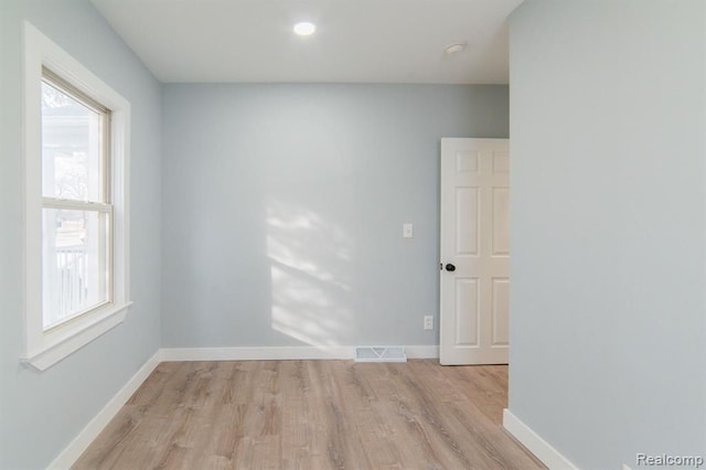 spare room featuring light wood-style flooring, baseboards, and visible vents