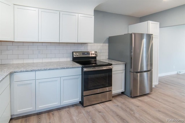 kitchen featuring light wood finished floors, white cabinetry, appliances with stainless steel finishes, and tasteful backsplash