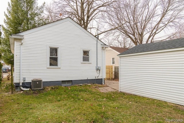 rear view of property with central air condition unit, a yard, and fence