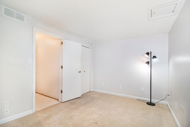 empty room with carpet, visible vents, and baseboards