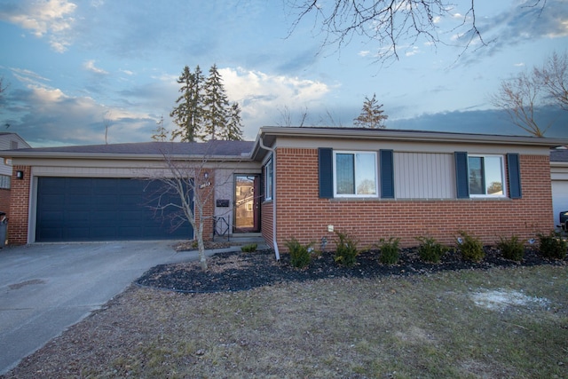 view of front facade with an attached garage, driveway, and brick siding