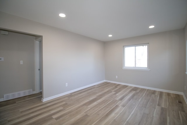 empty room featuring light wood finished floors, visible vents, and recessed lighting