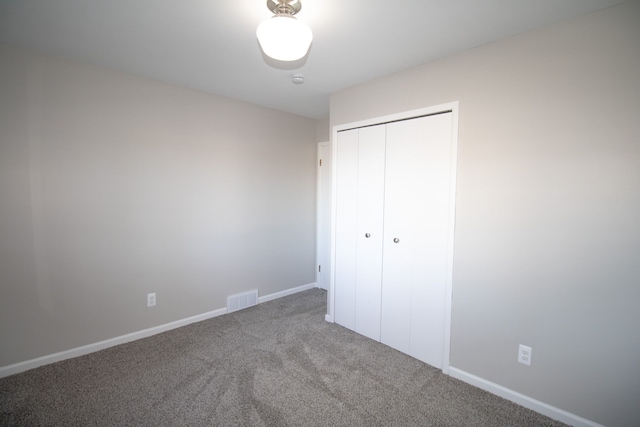 unfurnished bedroom with baseboards, a closet, visible vents, and carpet flooring