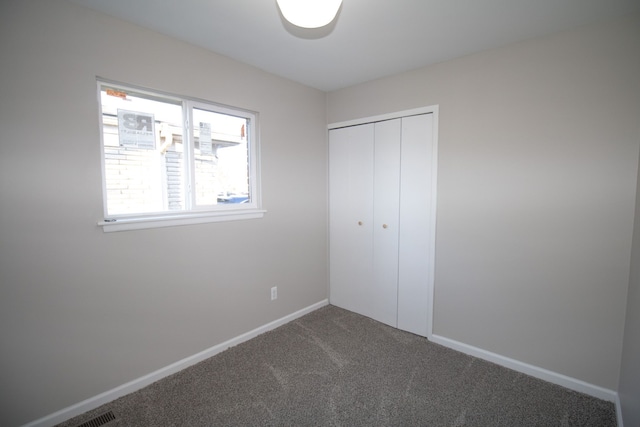 unfurnished bedroom featuring carpet floors, a closet, and baseboards