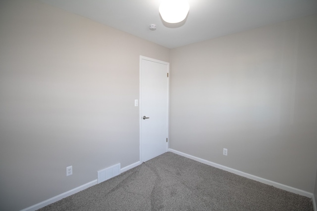 carpeted empty room featuring visible vents and baseboards