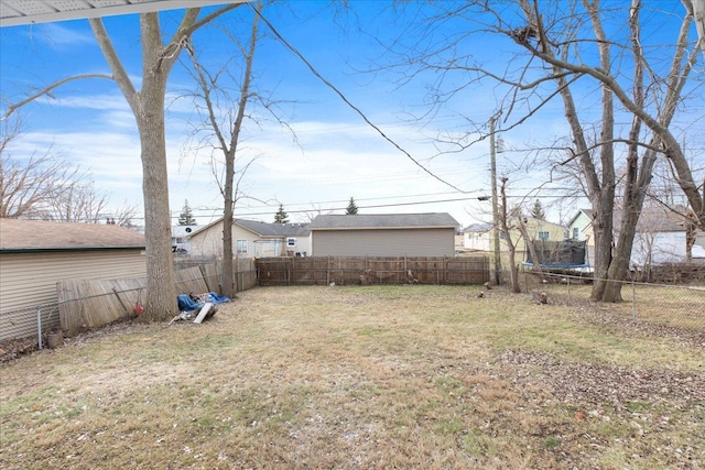 view of yard with a trampoline and a fenced backyard