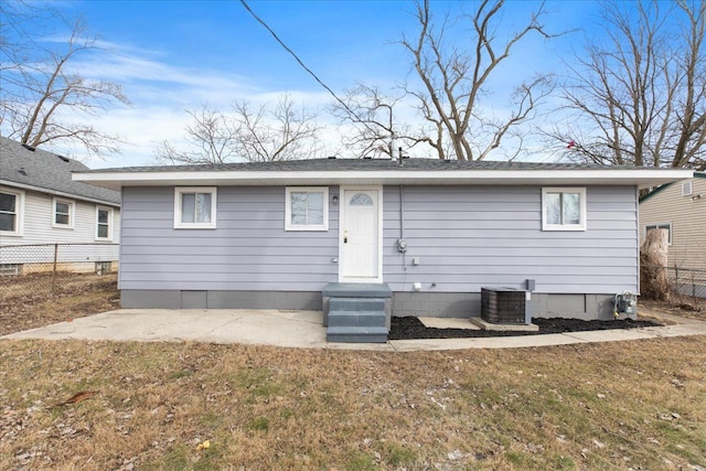 rear view of house with a yard, fence, and central air condition unit