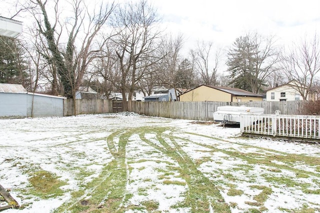 snowy yard with a fenced backyard