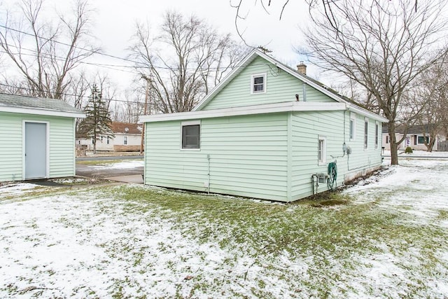 snow covered property with a chimney