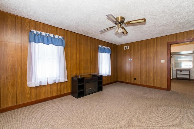 unfurnished bedroom featuring a textured ceiling, carpet floors, and multiple windows