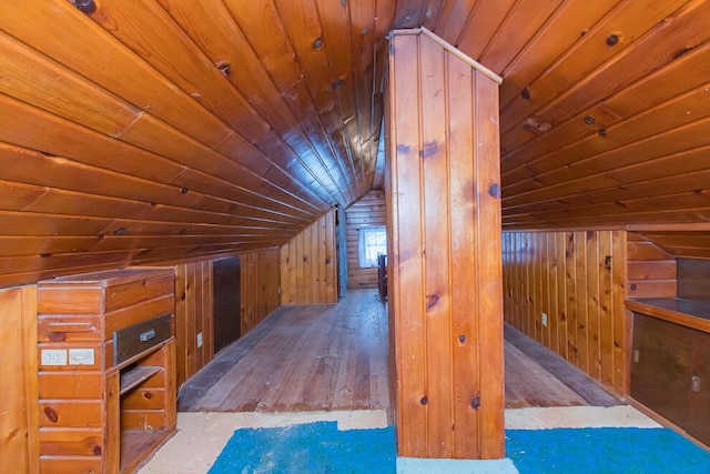 additional living space with vaulted ceiling, wood walls, wooden ceiling, and wood-type flooring