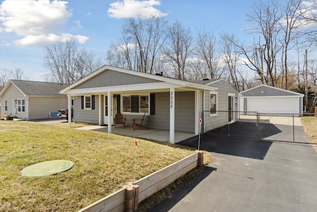 view of front of property featuring a front lawn, a detached garage, a porch, fence, and an outdoor structure