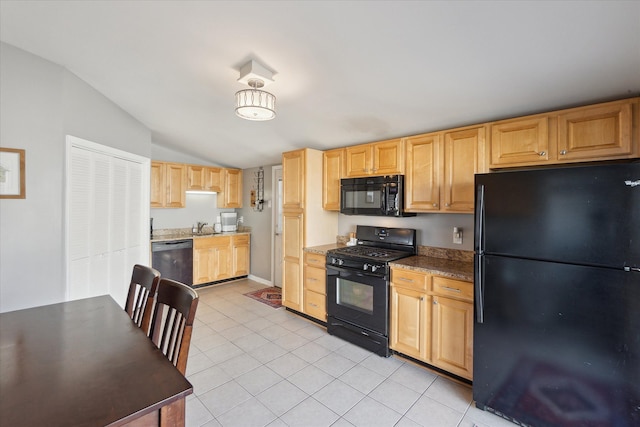 kitchen featuring light tile patterned floors, light brown cabinets, a sink, black appliances, and vaulted ceiling