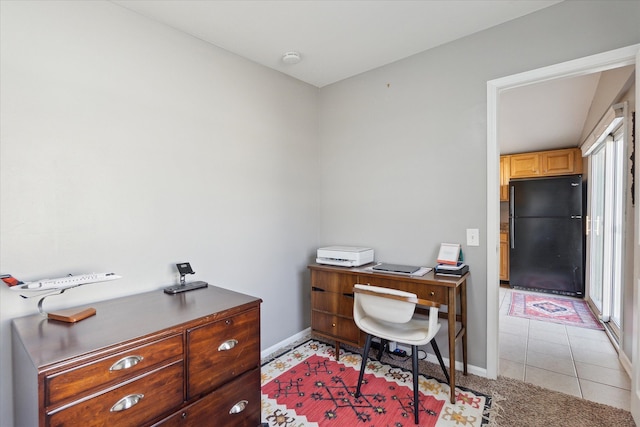 office area with light tile patterned floors, baseboards, and light colored carpet