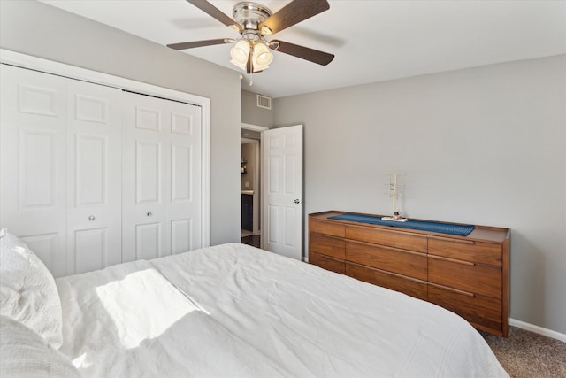 carpeted bedroom featuring a closet, visible vents, baseboards, and a ceiling fan