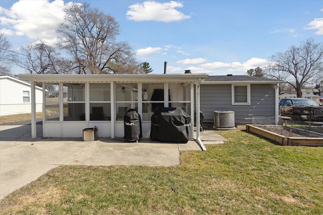 back of property with a sunroom, cooling unit, a yard, a garden, and a patio