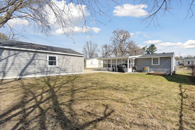 back of house featuring a lawn and a sunroom