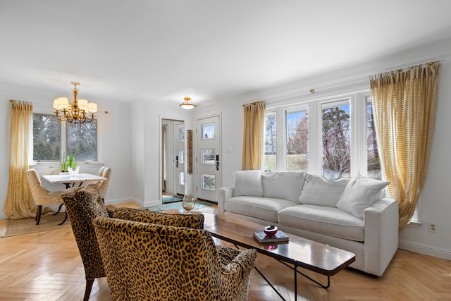 living area with baseboards and a chandelier